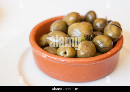 Green olives marinées concassées dans un bol d'argile. Apéritif traditionnel portugais Banque D'Images