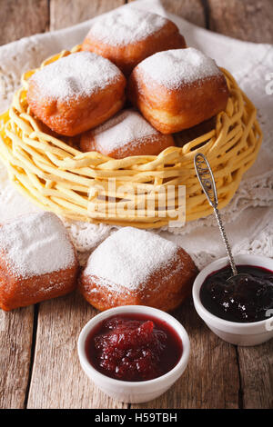 Beignets donuts français avec du sucre en poudre et de la confiture sur la table gros plan vertical. Banque D'Images