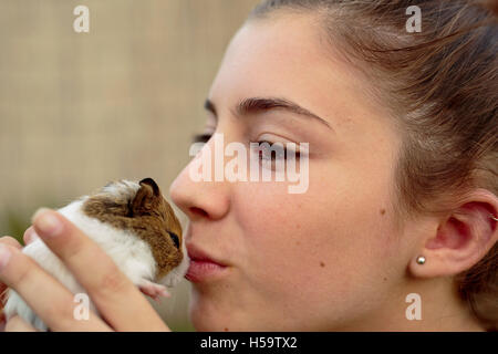Happy girl avec votre cobaye dans les mains, donnant des baisers. Capture horizontale. Banque D'Images