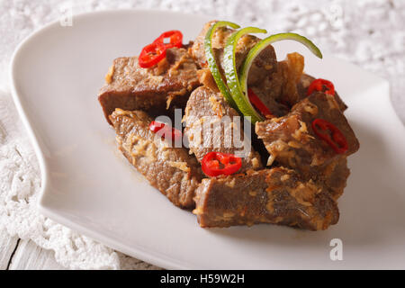 La cuisine indonésienne : Boeuf rendang mijotée dans du lait de coco aux épices gros plan sur une assiette. L'horizontale Banque D'Images