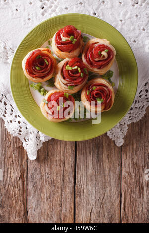 Petits pains au salami sous la forme de roses sur la table. Vue supérieure verticale Banque D'Images