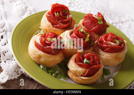 Beaux sandwiches chauds au salami sous la forme d'une fleur sur une plaque horizontale sur la table. Banque D'Images