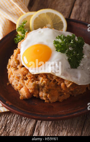 La cuisine arabe : Foul Medemes ful avec un oeuf au plat sur une plaque verticale close-up. Banque D'Images