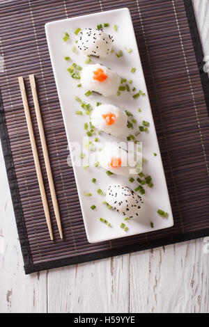 La nourriture japonaise onigiri boules de riz sur une plaque blanche. Vue supérieure verticale Banque D'Images