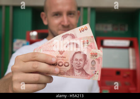 Libre de 100 baht thaïlandais note retirées d'ATM sur le visage de l'homme trouble Banque D'Images