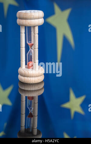 Oeuf en bois-timer set contre la réflexion de drapeau de l'UE comme métaphore pour le temps presse pour la zone euro, Bruxelles, et de l'UE. Banque D'Images
