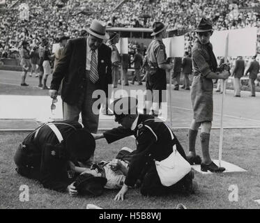 Cette image représente une victime aux Jeux Olympiques de Londres 1948. Les Jeux ont été remarquables pour leur retour après la seconde Guerre mondiale, et cet incident capture les défis physiques et les risques auxquels les athlètes ont été confrontés pendant la compétition. Banque D'Images