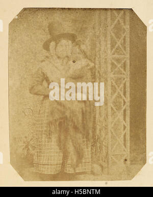 Une femme vêtue d'un costume gallois traditionnel tient un bébé, symbolisant l'héritage culturel gallois. L'image représente probablement les coutumes et les vêtements associés au pays de Galles, en particulier dans des contextes ruraux ou cérémoniels. Banque D'Images