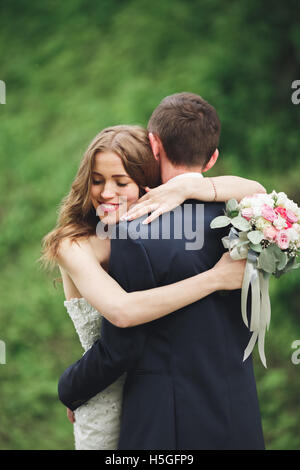 Happy wedding couple hugging and smiling les uns les autres sur l'arrière-plan de magnifiques plantes dans Castle Banque D'Images