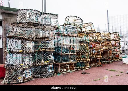 Filet de pêche et pots empilés sur le front de mer du port de Torquay Angleterre Royaume-Uni. Banque D'Images