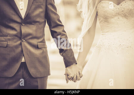 Groom et bride holding hands Banque D'Images