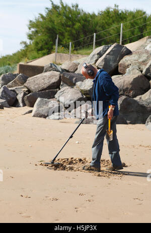 Metal detectorist sur la plage, au Royaume-Uni. Banque D'Images