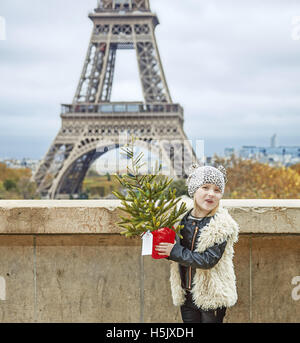 La saison des festivals à Paris. Full Length portrait of smiling girl moderne avec arbre de Noël dans l'avant de la tour Eiffel à Paris, France Banque D'Images