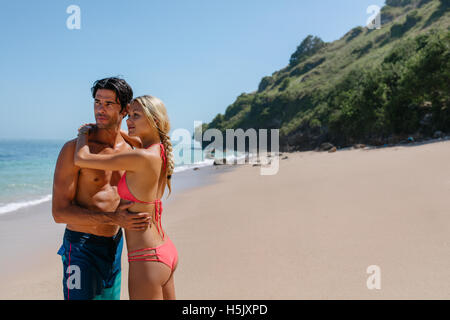 Portrait de belle jeune couple sur la plage et à la voiture. Woman in bikini et l'homme en short sur th Banque D'Images