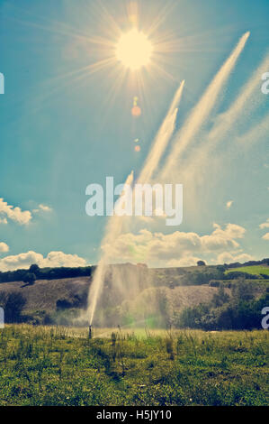 Le sprinkleur Grassy Field Against Sky Banque D'Images