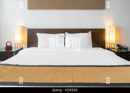 Oreiller blanc sur lit avec lampe de table en décoration d'intérieur chambre à coucher Banque D'Images