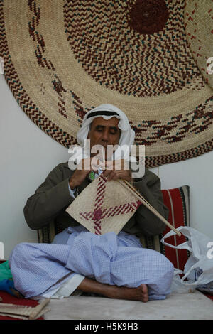 Personnes âgées Arabian homme assis sur le plancher et le tissage d'un mat Banque D'Images