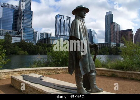 Statue de Stevie Ray Vaughan est sur le côté sud de Town Lake à Austin, Texas, avec le centre-ville d'Austin à travers le lac. Banque D'Images