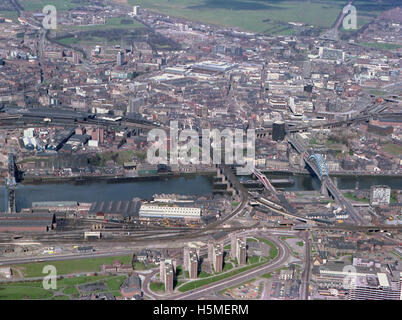 Cette photographie aérienne de 1978 capture plusieurs ponts emblématiques sur la rivière Tyne, y compris le Tyne Bridge et le High Level Bridge, ainsi que le Quayside et ses environs. L'image offre un instantané vivant du paysage industriel et architectural de Newcastle upon Tyne, mettant en valeur à la fois le développement de la ville et son patrimoine en matière de transport et d'infrastructure. Banque D'Images