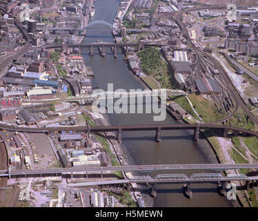 Une vue aérienne de 1983 montrant plusieurs ponts sur la rivière Tyne, y compris le pont Tyne, le pont de High Level et le pont Redheugh. L'image illustre le développement architectural et l'infrastructure de transport de Newcastle et Gateshead. Banque D'Images