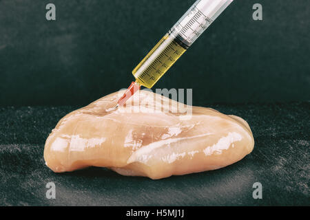 Seringue avec un liquide est injecté à un morceau de viande. Illustration conceptuelle pour les Hormones et d'antibiotiques dans la production alimentaire. Banque D'Images