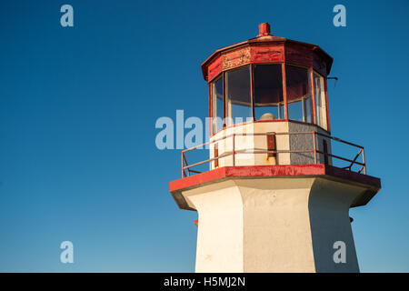 Haut d'un vieux phare rouge et blanc sur ciel bleu en Gaspésie, Québec (percé). Banque D'Images