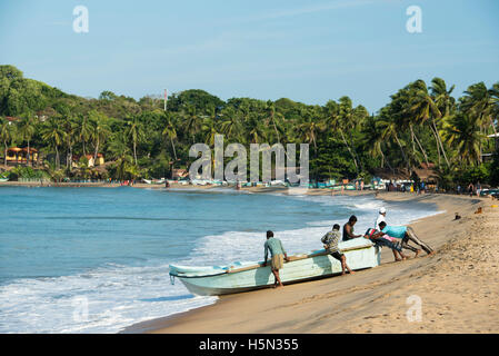 Pousser les pêcheurs d'un bateau en mer, d'Arugam Bay, au Sri Lanka Banque D'Images