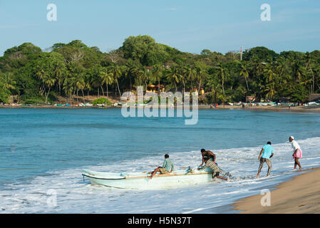 Pousser les pêcheurs d'un bateau en mer, d'Arugam Bay, au Sri Lanka Banque D'Images