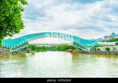 La paix moderne pont sur rivière Kura à Tbilissi, centre fait de métal et de verre, la Géorgie. Banque D'Images