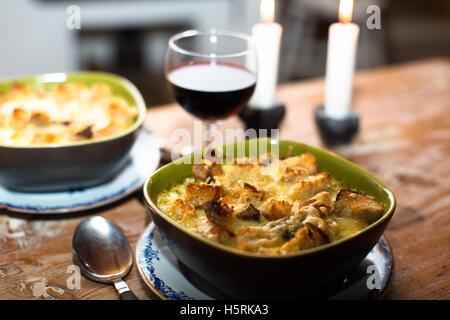 Une belle soupe avec un verre de vin rouge et allumé des bougies Banque D'Images