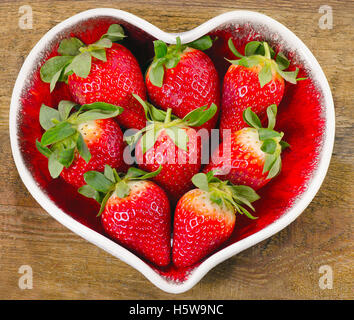 Les fraises dans un bol en forme de coeur. L'alimentation saine. Banque D'Images