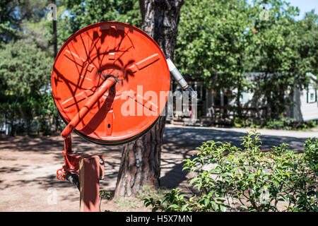 Extincteur dans un jardin. Arbres et maisons Banque D'Images