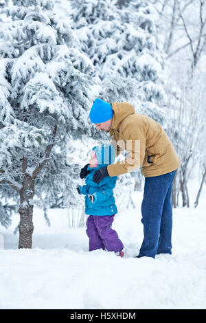 Père et fille marcher dans la neige profonde à winter park. Le temps passé en famille. Le père aide à explorer le monde. L'enfance Banque D'Images