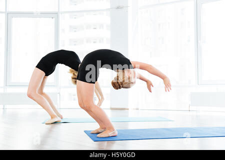 Professeur de danse féminine et little girl doing stretching exercices ensemble au ballet school Banque D'Images