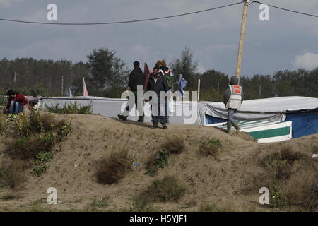 Calais, France. 22 octobre, 2016. Les réfugiés se tenir sur une dune, en regardant vers l'entrée principale du camp. La vie quotidienne dans la jungle se poursuit avec quelques jours d'aller à l'expulsion du camp par l'État français. Cependant de plus en plus de gens quittent le camp et le nombre de tentes vides et des huttes augmente. Crédit : Michael Debets/Alamy Live News Banque D'Images