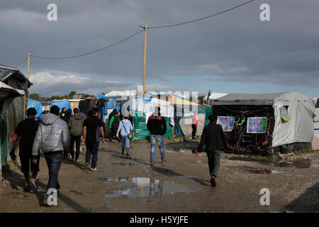 Calais, France. 22 octobre, 2016. Les réfugiés naviguer parmi les flaques dans la jungle, en raison de la pluie havy. La vie quotidienne dans la jungle se poursuit avec quelques jours d'aller à l'expulsion du camp par l'État français. Cependant de plus en plus de gens quittent le camp et le nombre de tentes vides et des huttes augmente. Crédit : Michael Debets/Alamy Live News Banque D'Images