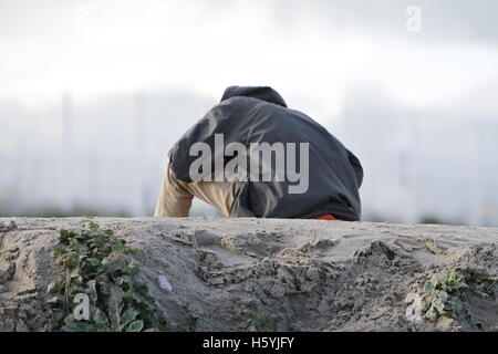 Calais, France. 22 octobre, 2016. Un réfugié se trouve au sommet d'une dune. La vie quotidienne dans la jungle se poursuit avec quelques jours d'aller à l'expulsion du camp par l'État français. Cependant de plus en plus de gens quittent le camp et le nombre de tentes vides et des huttes augmente. Crédit : Michael Debets/Alamy Live News Banque D'Images