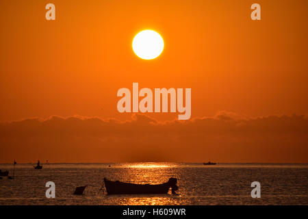 Lever du soleil rouge avec silhouette de bateau, l'Italie du Sud. Banque D'Images