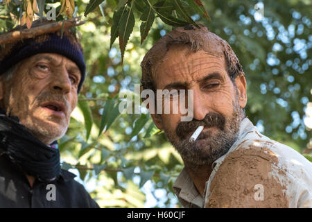 10 Muharram (Ashura), Bijar, des hommes couverts de boue Cigarette Banque D'Images