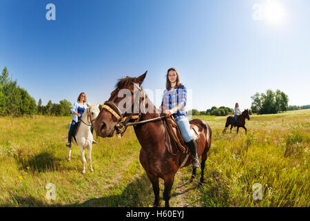 Trois cavaliers femelle de l'équitation dans le champ Banque D'Images