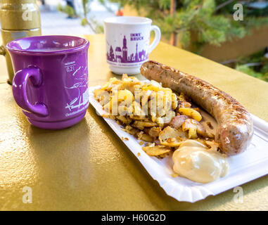 Vin chaud tasses et la plaque avec wurstel et les pommes de terre sur une table au marché de noël de l'hiver à Innsbruck, en Autriche. Banque D'Images