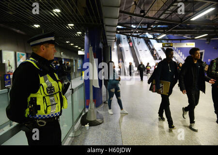 Un agent de police se tient dans le hall d'entrée de la station de métro North Greenwich. Banque D'Images