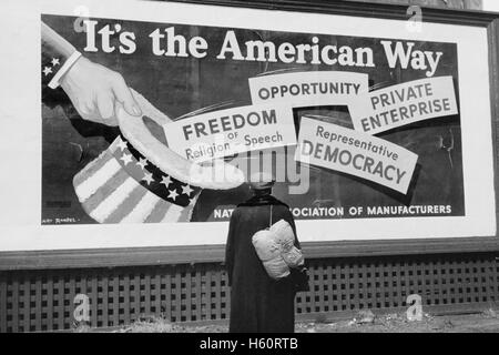 Homme debout en face de l'Association nationale des gestionnaires d'affichage, Dubuque, Iowa, USA, John Vachon pour la Farm Security Administration, Avril 1940 Banque D'Images