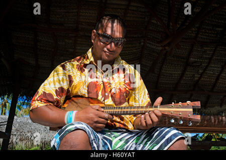 Aitutaki. L'île de Cook. Polynésie française. Océan Pacifique Sud. Jouant le ukulélé (guitare) typiquement polynésien à Aitutaki Punani Cultur Banque D'Images