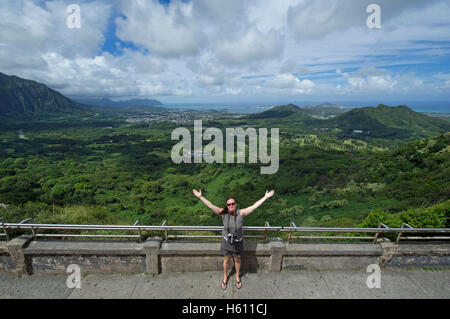 Tourisme femme debout à Nuuanu Pali Lookout pittoresque offrant une vue panoramique de l'île Oahu Hawaii Banque D'Images