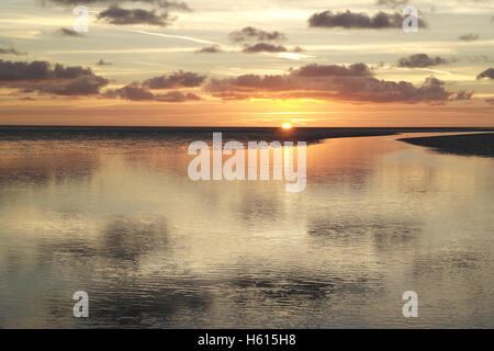 Soleil jaune gris en dessous de stratocumulus plus étendue plage de sable plat avec Canal d'eau de mer, Fairhaven, Lytham, UK Banque D'Images