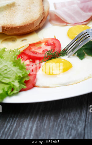 Libre de la plaque avec les œufs et les tomates sur le tableau noir. Vertical image Banque D'Images