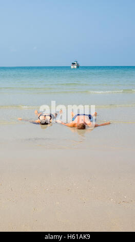 Couple lying in the land laver et tenir la main sur un bounty beach. Pour les textes de l'espace Banque D'Images