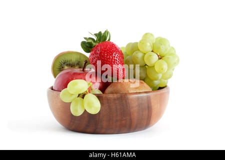 Joli bol en bois plein de divers fruits sur fond blanc Banque D'Images