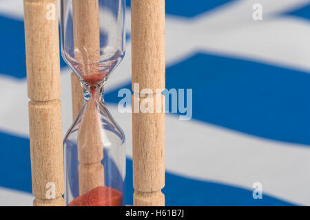 Sablier en bois sur un drapeau grec - une métaphore visuelle pour le temps presse pour banques grecques, les prêts et le système financier. Banque D'Images